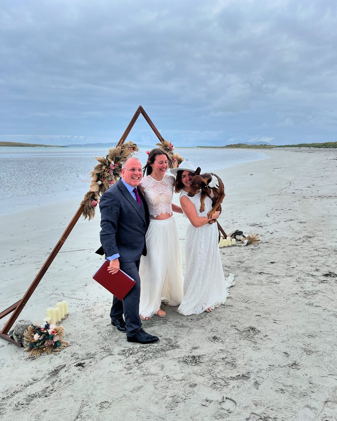 Two brides with their dog and John Paul on a Hebridean beach
