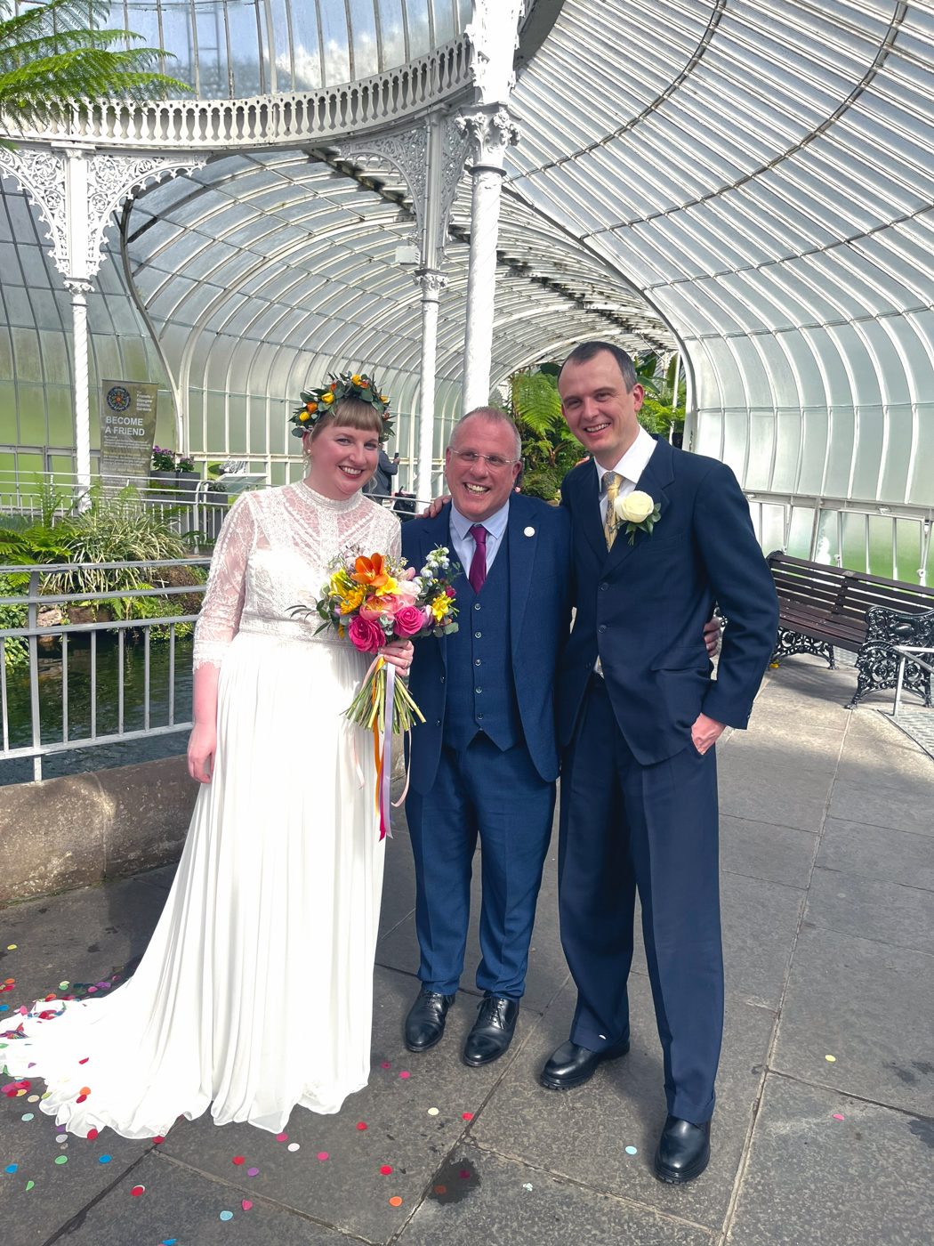 A newly married couple with celebrant John Paul Fitzpatrick under the glass dome of the Kibble Palace, Glasgow Botanic Gardens