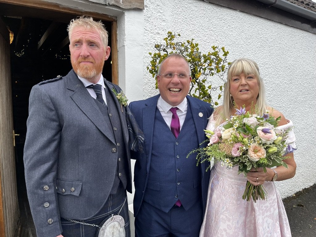 Christine and Stewart with their celebrant outside the barn at Fruin Farm