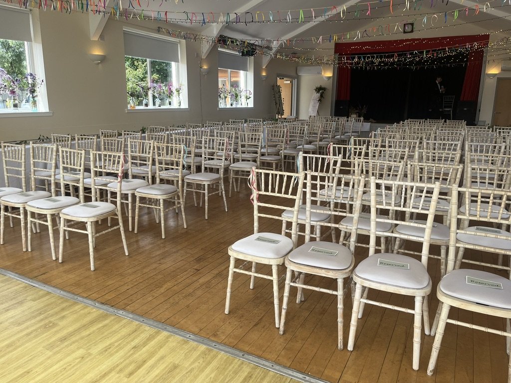 Kinlochard Village Hall dressed for a wedding — chiavari chairs, ribbons and fairy lights